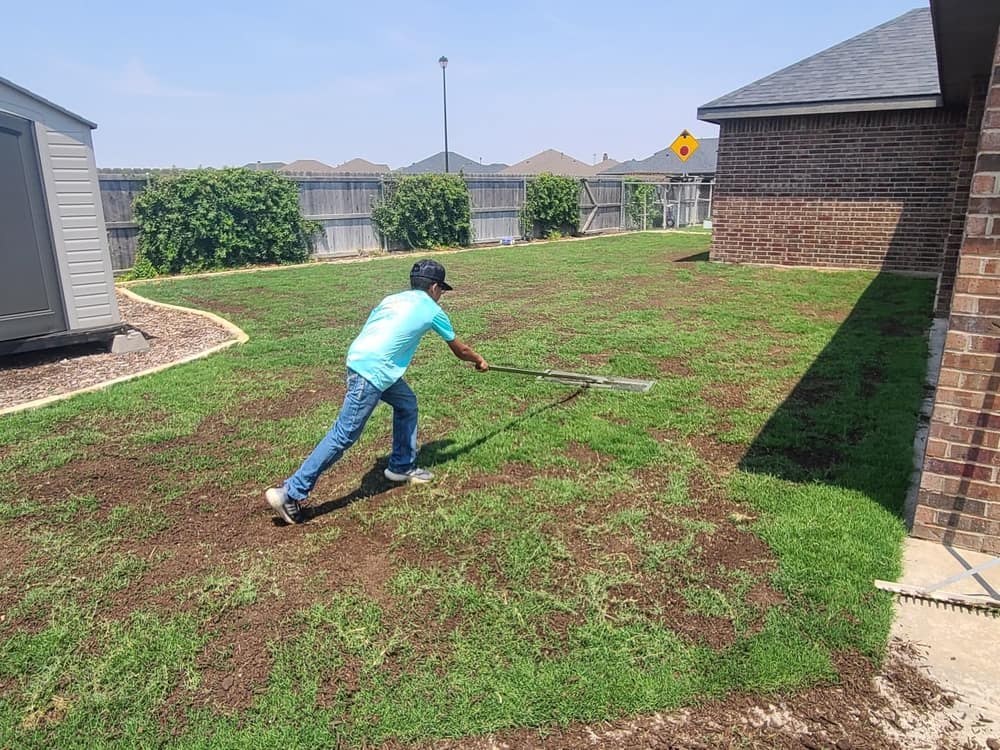 Working the compost into the turf with a leveling rake